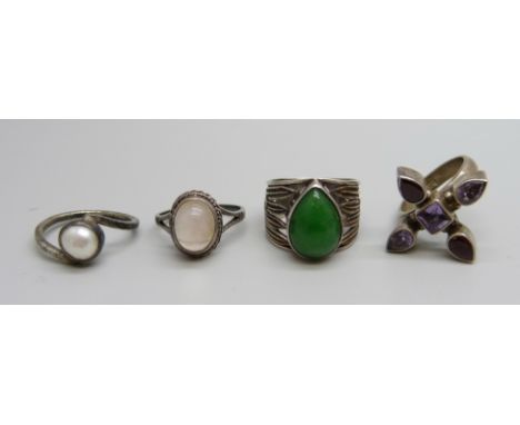 An Arts and Crafts silver and green stone ring and three other silver rings 