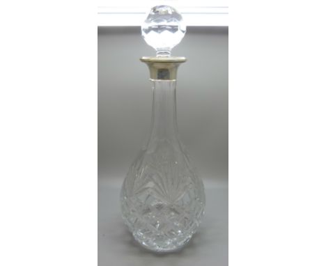 A silver rimmed cut crystal glass decanter 