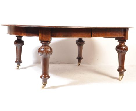 A large late 19th Century mahogany extending dining table of rectangular form having a rounded chamfered edge top with windin
