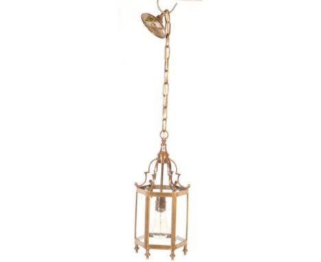 A 20th century brass and glass porch lantern. The lantern having an hexagonal shaped body with glass panels, dome top and cha