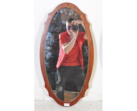 A pair of vintage retro mid 20th century Danish inspired teak wood wall hanging mirrors. The mirrors of and oval set on a sha