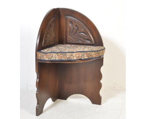 A reproduction Jacobean revival corner chair with carved detailed arches, tapestry loose cushion. Raised on pierced arched up