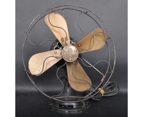 An early 20th century circa 1930s Art Deco electric desk fan having a a protective metal cage, brass blades and cast metal bo