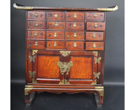 A vintage 20th century Chinese Oriental exotic hardwood chest of drawers having flared curved top over a bank of sixteen shel