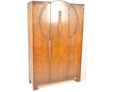 An early 20th century Art Deco oak veneer wardrobe. The wardrobe being decorated with typical 1930’s Art Deco raised decorati