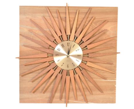 An Art Deco style sunburst atomic clock having a bronzed clock face with Arabic numerals to the chapter ring and wooden sun b