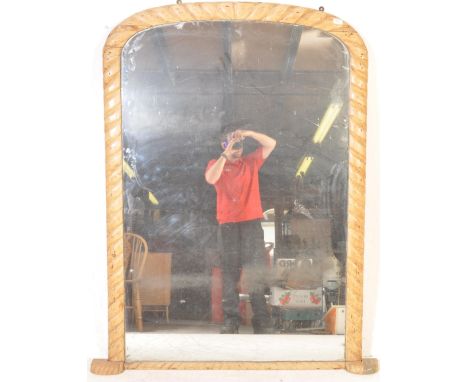 A large 19th century Victorian archtop overmantel wall mirror having a scrolled carved frame with quarter panel wood back . M