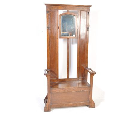 An early 20th century circa 1930’s oak hall stand / settle. The stand having a rectangular bevelled glass mirror to the centr