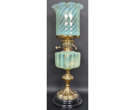 A 19th century Victorian uranium glass oil lamp / paraffin lamp being raised on a brass base with uranium glass reservoir and