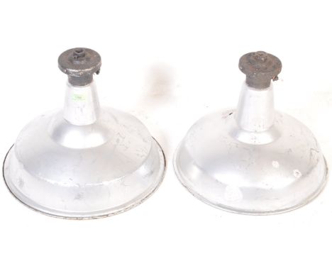 A pair of vintage retro mid 20th century factory industrial pendant lights. The light of a conical form with cast iron bracke