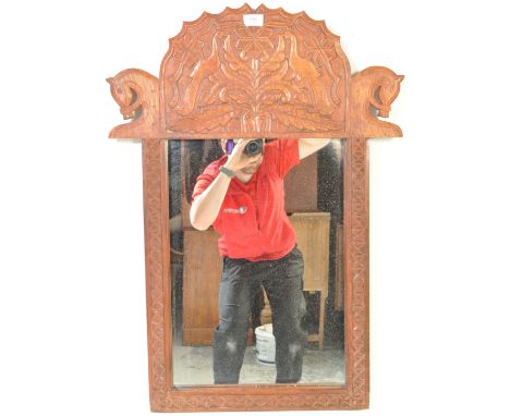 A vintage 20th century exotic hardwood carved mirror having foliate and avian decoration with geometric patterns to the side.