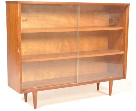 A vintage retro mid 20th century teak wood bookcase. The bookcase of a rectangular form having glass sliding doors with adjus