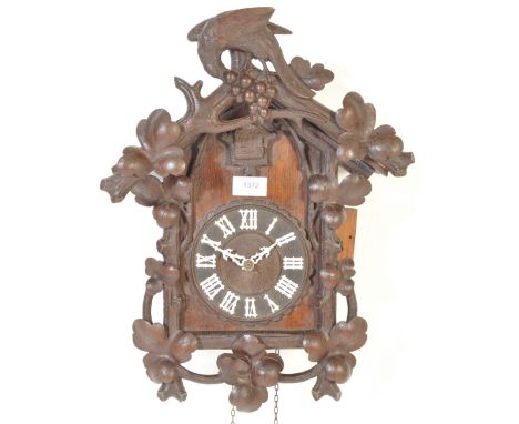 A vintage retro 20th century Black Forest wall cuckoo clock. The large clock having hand carved floral motifs and birds motif
