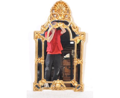 A 20th century resin cast gilt rococo overmantel mirror. Of arched form the central mirror plate within crested rococo gilt p
