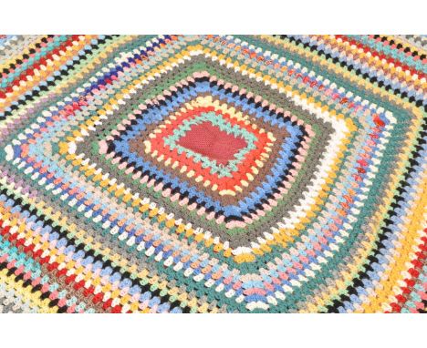 A vintage retro mid 20th century Welsh blanket tether with a bedspread. The hand woven blanket having multicolour geometrical