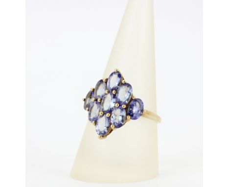 A hallmarked 9ct yellow gold ring set with large oval cut tanzanites, (S).