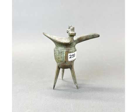 A Chinese archaic form bronze wine vessel, with dragon handle and standng on three feet, H. 18cm.