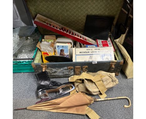 A metal trunk and contents including books, postcards, ice skates etc.