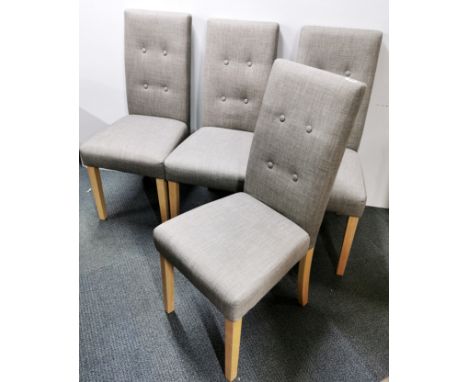 Four modern grey upholstered button backed dining chairs.