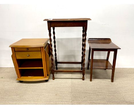A 20th century oak side table with barley twist legs together with a light oak side table on castors with magazine rack sides