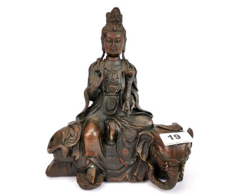 A Tibetan bronze figure of the Godess Guanyin seated on an elephant, H. 22cm.