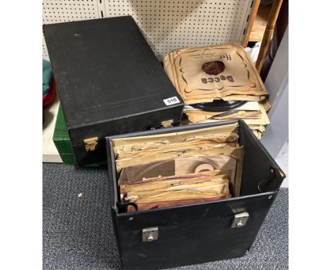 A portable wind up record player with a quantity of 78 RPM records.
