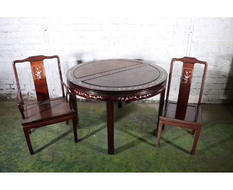 A Chinese hardwood circular extending dining table with two leaves, 46cm each, mother of pearl inlay to frieze, with 10 match