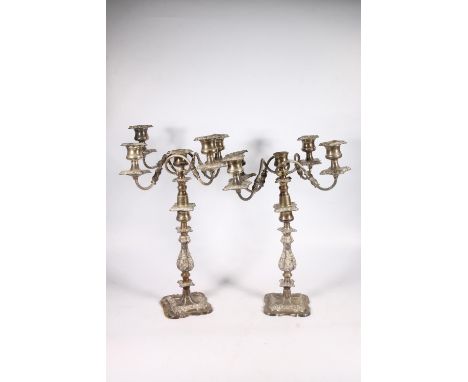 Pair of silver plated four branch, five light candelabra with scroll arms and relief foliate decoration, 46cm tall. (2)  Fair