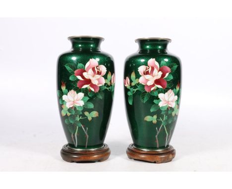 Pair of Japanese ginbari cloisonne enamel vases decorated with rose design on a deep green ground, 18cm tall, with hardwood s