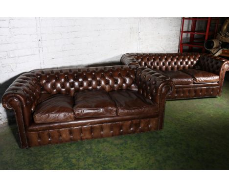 Pair of brown leather button-back three-seater Chesterfield sofas, 196cm long. Good  overall condition with general wear and 