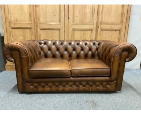 Modern two seater leather chesterfield field sofa in brown with castors. W163 D85 H70 cm approximately. Made by Thomas Lloyd.