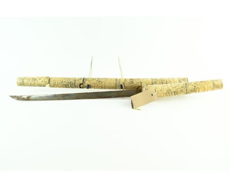 A late 19th century Japanese carved bone wakizashi style sword, the handle and scabbard decorated with figures in traditional