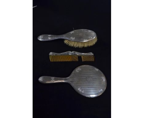 Silver three piece dressing table set, William Hutton & Sons Ltd, Birmingham 1911-14, comprising a hand mirror, brush and com