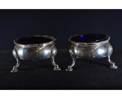 Pair of early George III silver salts, D & R Hennell, London 1768, of circular form raised upon three hoof feet, with blue gl