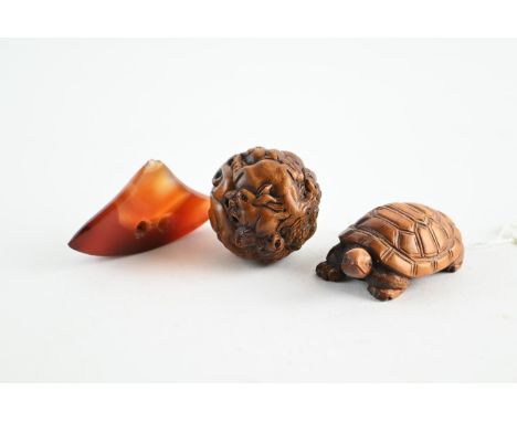 Three Netsukes, including a tortoise, carved walnut and a polished stone in the form of a Netsuke 