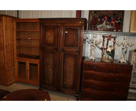 A mahogany two door wardrobe raised on bracket supports 