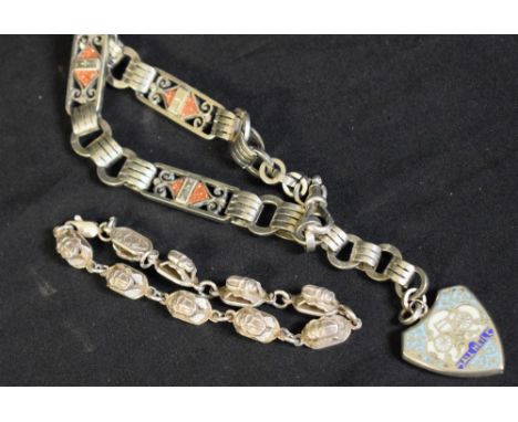 An early 20th century silver coloured metal and gold stone fancy-link bracelet, the shield shaped enamel fob decorated with a