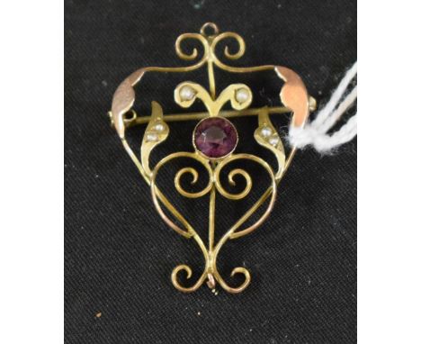 An Edwardian amethyst effect paste and seed pearl open heart scrolling pendant brooch, two tone yellow and rose gold frame, s