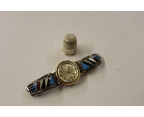 An Eterna Matic wrist watch and a white metal thimble