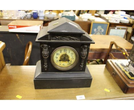 A late Victorian black slate two hole mantel clock