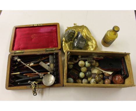 A box containing various pens; a white metal spoon with coin set bowl; a wooden box of marbles etc.