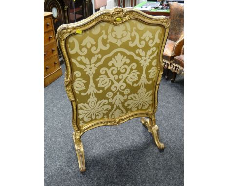 A Rococo style gilded & ebonized carved fire screen with double-side silk fabric panel