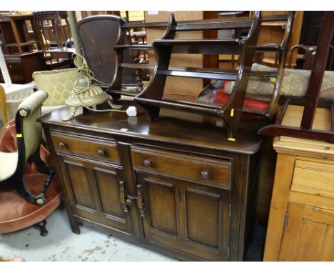 An Ercol dresser base in dark wood with two Ercol plate racks