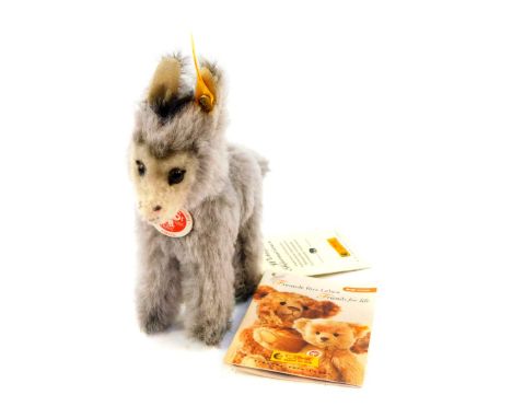 A Steiff figure of an Alpaca, 052866, with button label, and card details, 14cm wide.