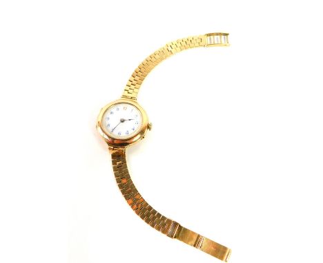A lady's early 20thC 9ct gold circular cased wristwatch, white enamel dial bearing Arabic numerals, Swiss movement, on a 9ct 