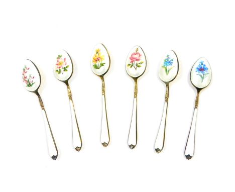 A set of six silver gilt and enamel coffee spoons, painted with flowers against a white guilloche and enamel ground, cased, E
