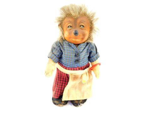 A Steiff 1960's Micki figure, of a hedgehog wearing a blue chequered top and red chequered trousers, with apron, bearing labe