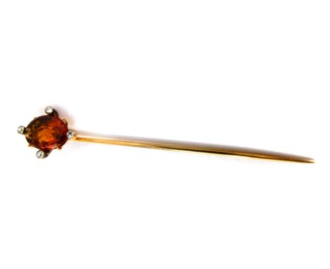 A Victorian topaz stick pin, intaglio carved with a classical goddess, set with four diamonds at points, in yellow metal.