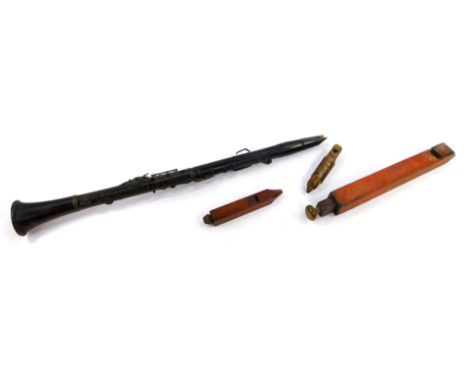 A 19thC rosewood clarinet, 67.5cm long., a rustic whistle carved with a head of a bird, and two further woodwind instruments.