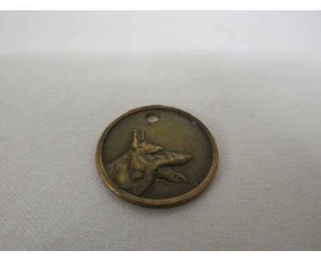 AN EARLY 20TH CENTURY FRENCH DOG TAG, THE CIRCULAR TAG CAST WITH AN ALSATION TO THE FRONT AND ENGRAVED 'DOCTEUR MAILLARD 16 R